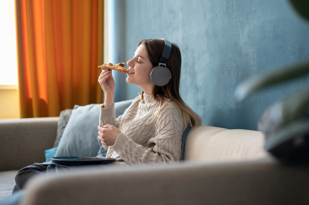 young-woman-eating-pizza-listening-music